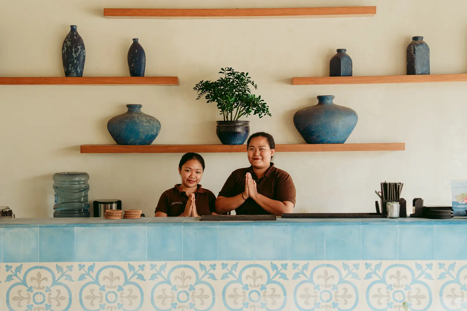 Two Pronoia team members greeting guests at the restaurant counter