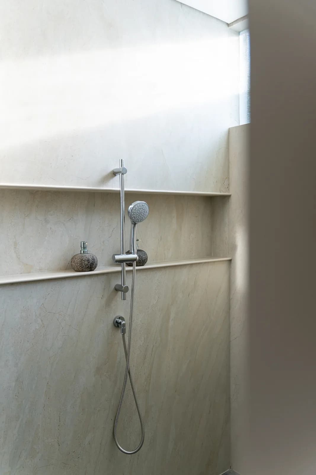 Stone shower wall and fittings in the villa bathroom