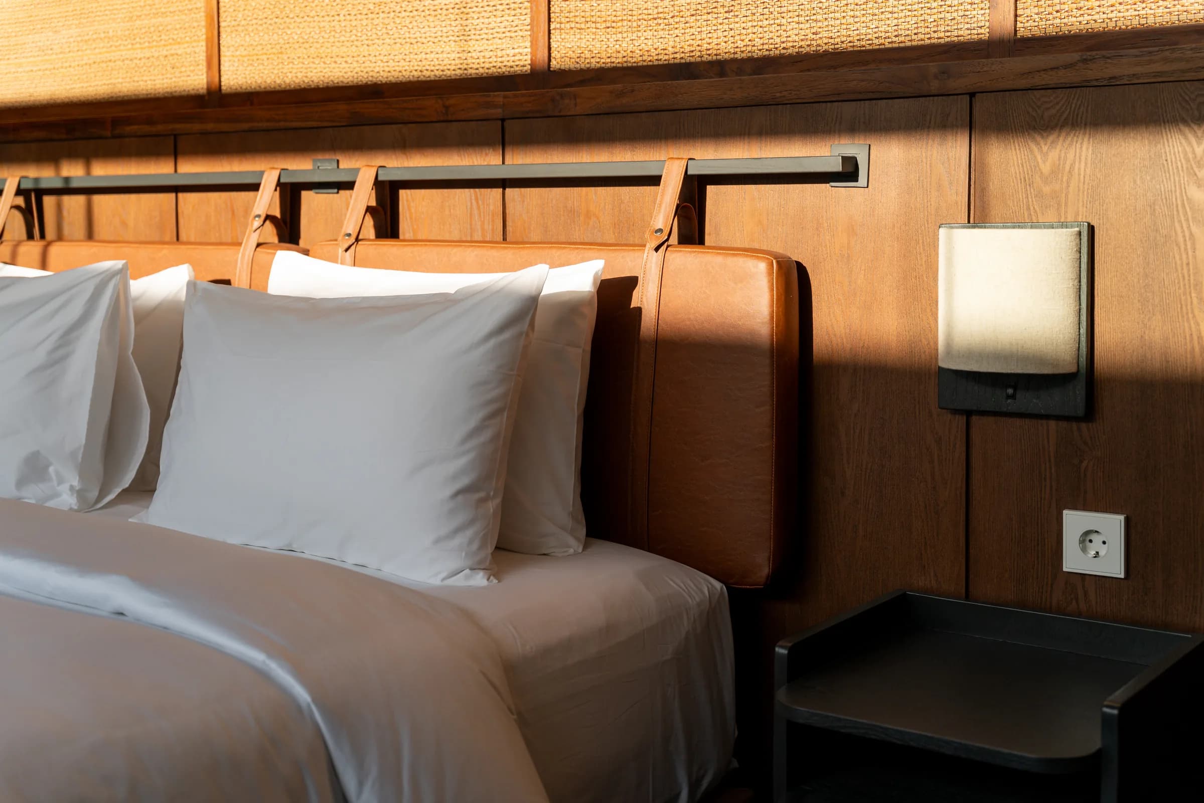 Teak headboard and bedside detail in the villa bedroom
