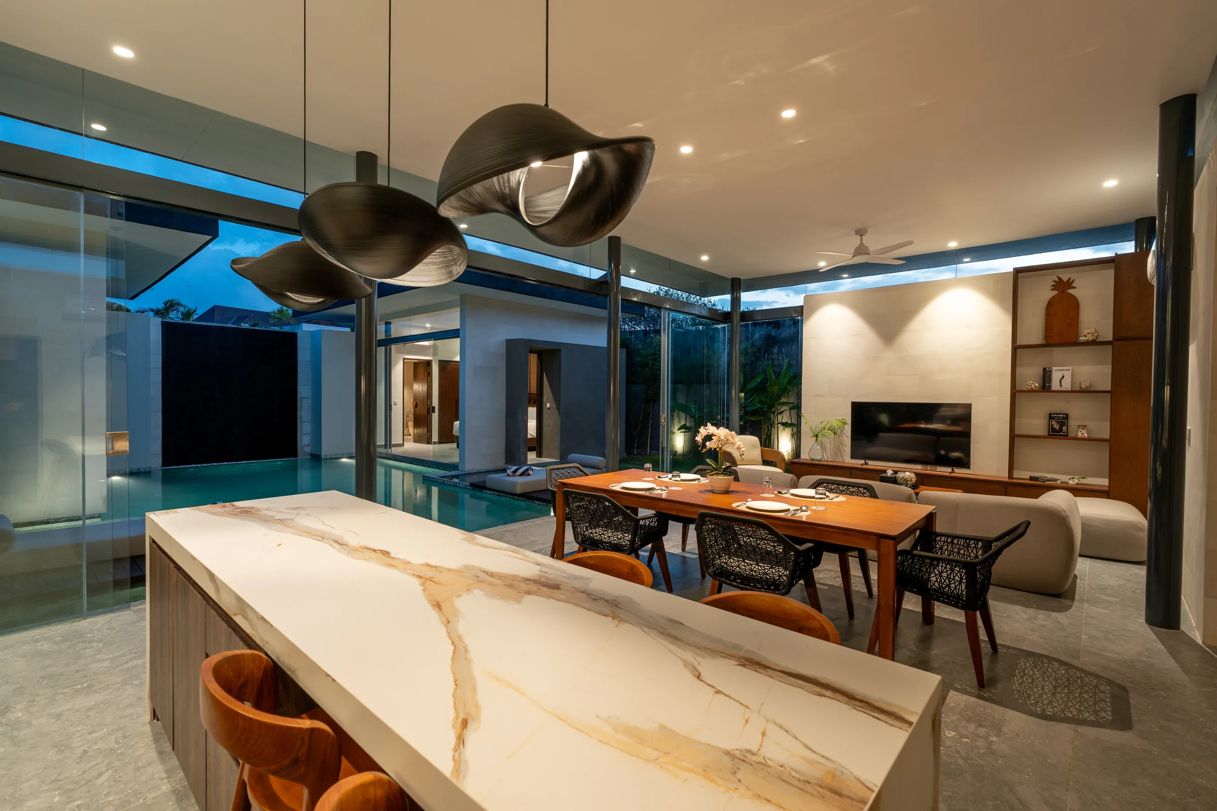 Two-bedroom villa living and dining area illuminated at night